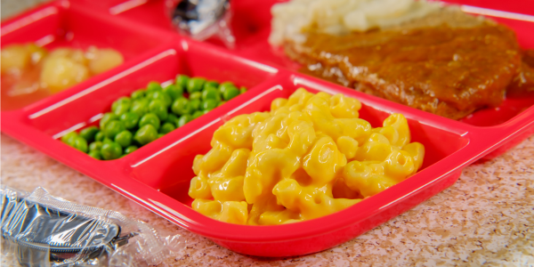 photo of a school lunch tray with peas, corn, stew, potoatoes